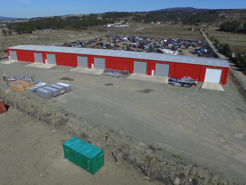 50‘ x 82‘ x 19‘ storage warehouse with bone white roof, crimson red wall panel, framed opening and personnel door