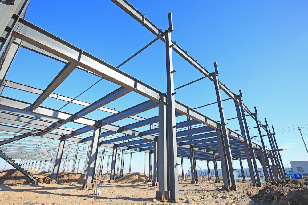 Angled view of steel beams arranged in building frame outdoors